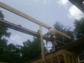Carpenter setting a ridge beam over a new addition frame — Ice Dam Removal by Roofing Brothers in Rainbow City