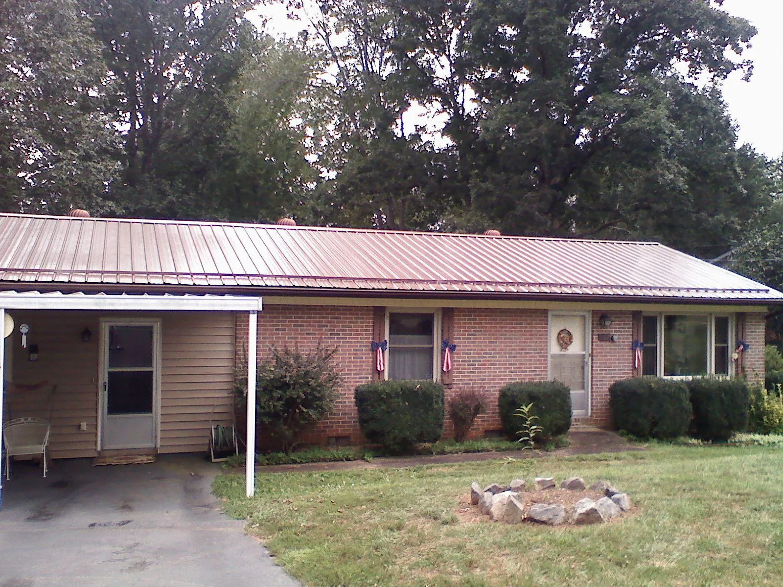 Bronze metal roof and carport on a brick ranch home — Roof Repair work by our crew in Rainbow City