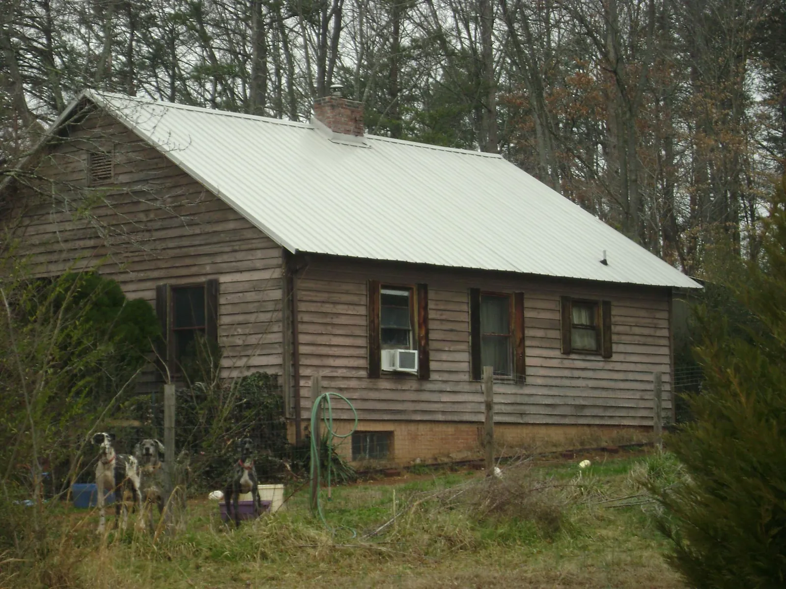 White metal roof on an old wood sided farmhouse, from a Metal Roof Installation job in Rainbow City